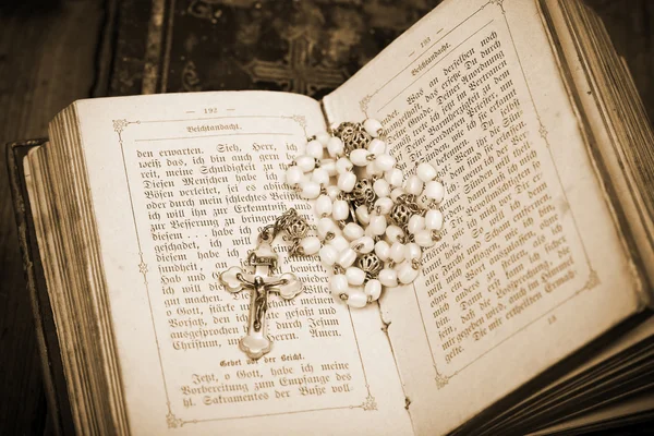 Vintage crucifix on sides of opened ancient bible, sepia, — Stock Photo, Image