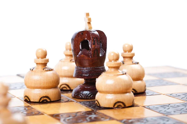 Chess King surrounded by opposing pawn, white background, copy space — Stock Photo, Image