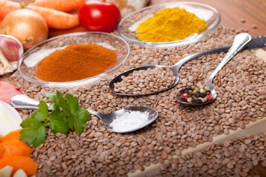 Ingredients for lentil soup on wooden plate, with curry spice, vegetables, salt, pepper clipart