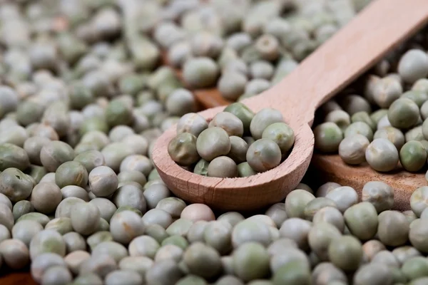 Wooden spoon on heap of green peas, — Stock Photo, Image