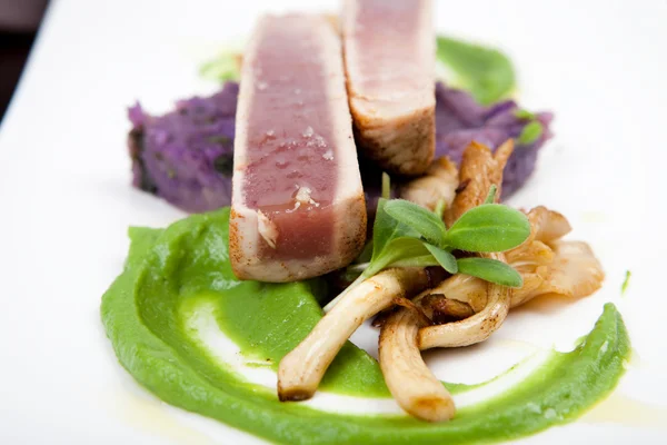 Fillet of tuna with oyster mushrooms, green pea puree and potatoes — Stock Photo, Image