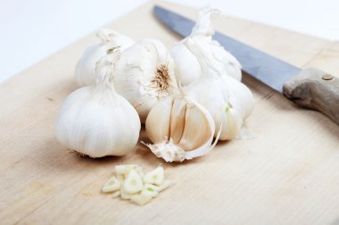 Ahşap masa, beyaz zemin üzerine bıçakla sarımsak