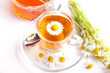 Papatya çayı çiçekleri ve beyaz zemin üzerine ballı