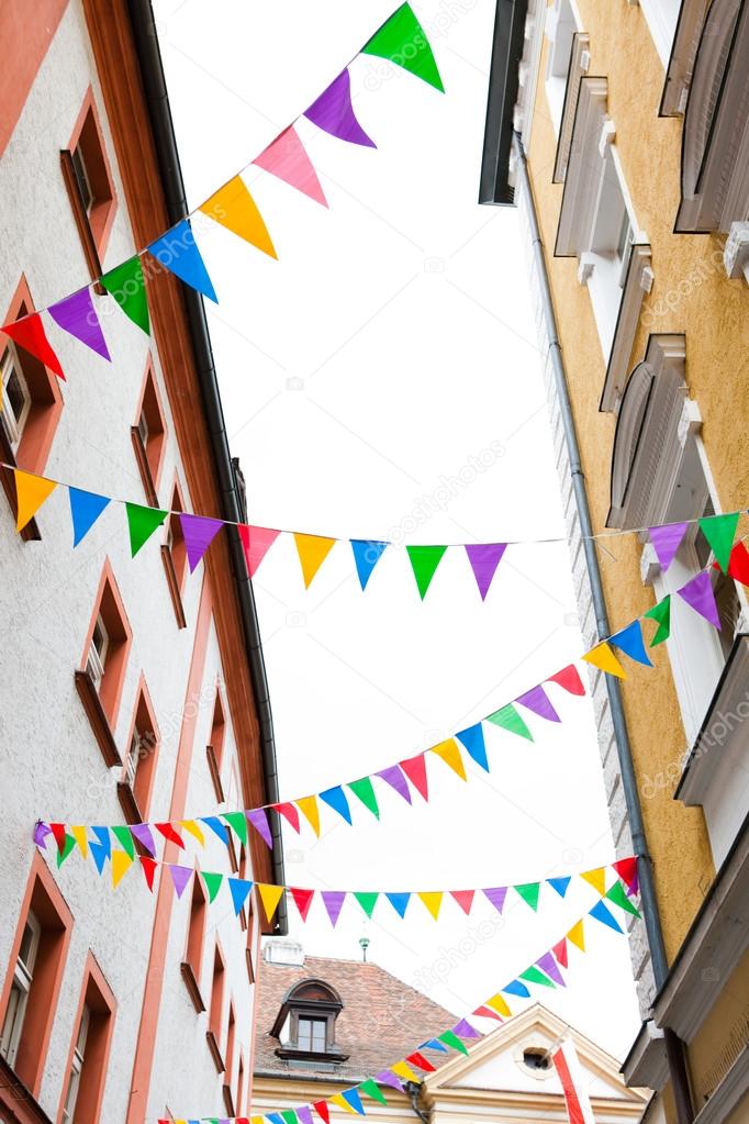 colorful pennants on ropes hanging on house facades
