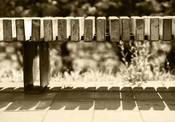 Horizontale sepia park bench bokeh achtergrond — Stockfoto