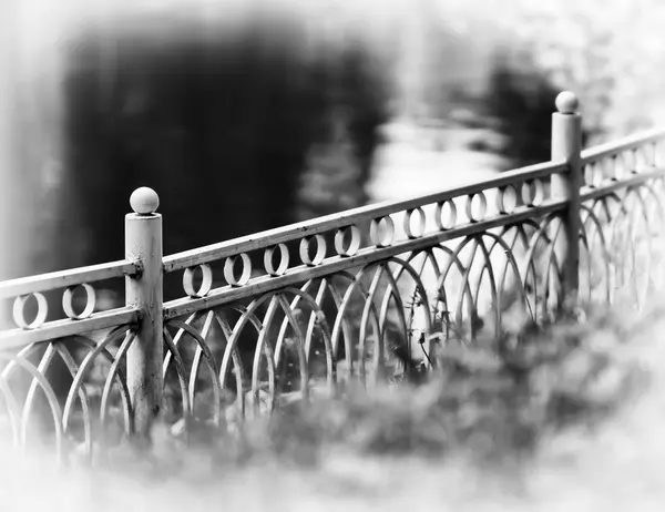 Horisontella diagonal svart och vitt staket i park bokeh vinjett — Stockfoto