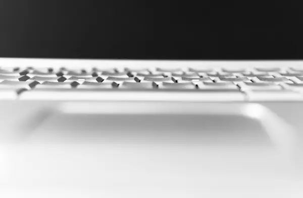 Horizontal black and white laptop keyboard bokeh background — Stock Photo, Image