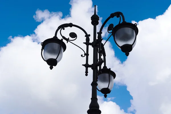 Vintage lamp on blue sky with clouds background Stock Picture