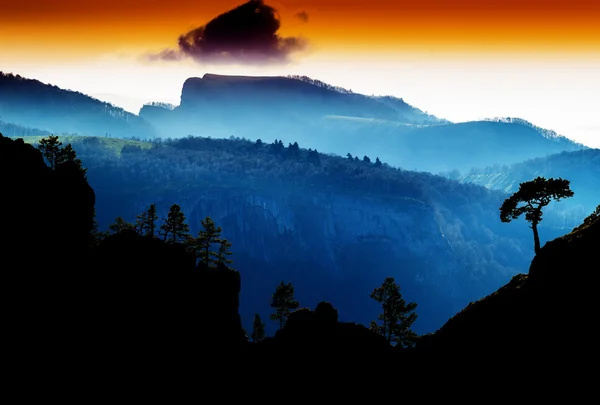 Árvores montanhosas horizontais em rochas silhueta pôr do sol b — Fotografia de Stock
