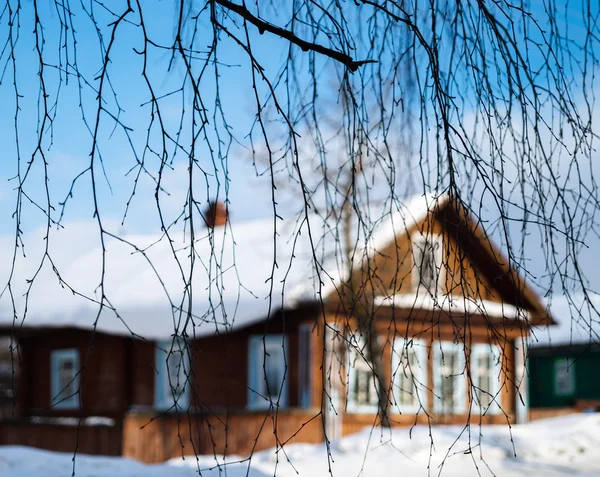 Russische huis via boom takken achtergrond — Stockfoto