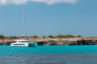 Yatch turkuaz bir plaja demir attı.