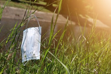 Burun maskesi yeşil çimenlere düştü ve çevreyi yok etti.