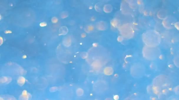 Goldenes Bokeh Dreht Sich Und Fällt Auf Blauem Hintergrund — Stockvideo