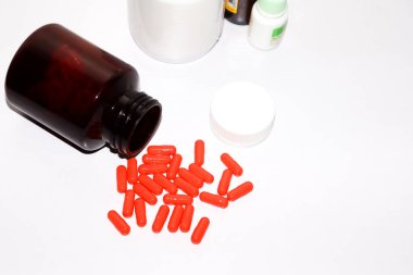 Beyaz arka planda ilaç şişesi ve ilaç hapları