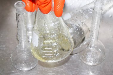 Laboratuvardaki kimyasal camları eldivenle temizle.