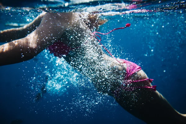 Mujer nadando bajo el agua en un océano — Foto de Stock