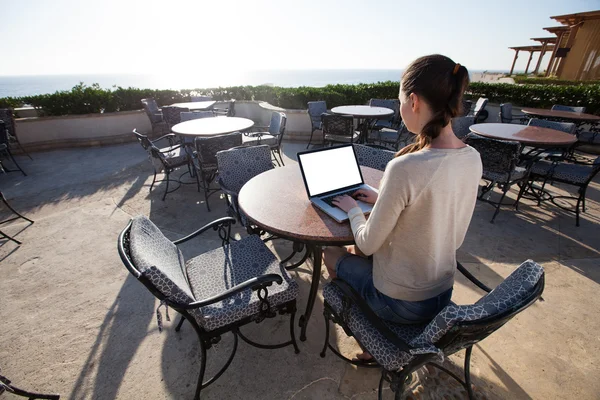 Femme d'affaires tapant sur son ordinateur portable avec sunflare sur la station — Photo