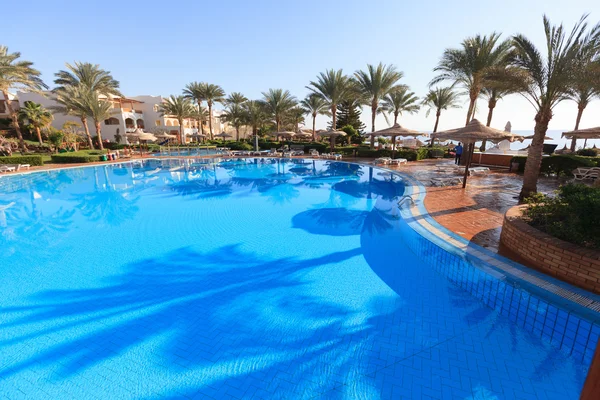 Beach resort in tropics with palms and water — Stock Photo, Image