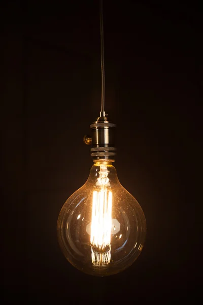 Vintage light bulb over dark — Stock Photo, Image