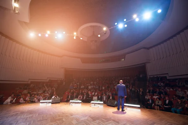 Imagen borrosa de un hombre de negocios dando una presentación en una conferencia — Foto de Stock