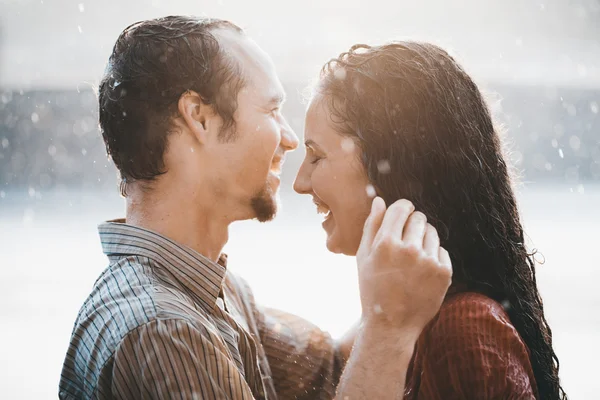 Casal apaixonado abraçando e beijando sob chuva de verão — Fotografia de Stock