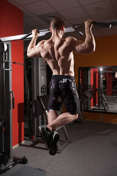 Uscular bodybuilder doing pull ups — Stock Photo, Image