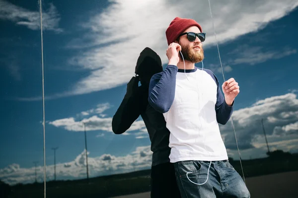 Hipster boy listening to music wearing hat — Stock Photo, Image