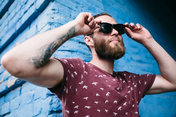 Mavi arka plan üzerinde güneş gözlüğü takıyor hipster çocuk