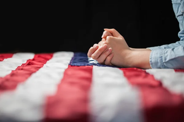 Hands praying over american flag — Stock Photo, Image