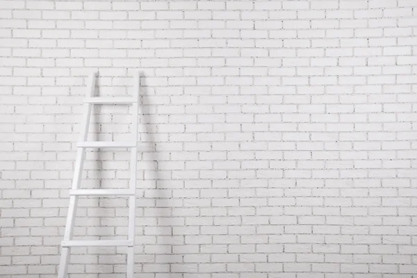 Witte bakstenen muur met ladder — Stockfoto