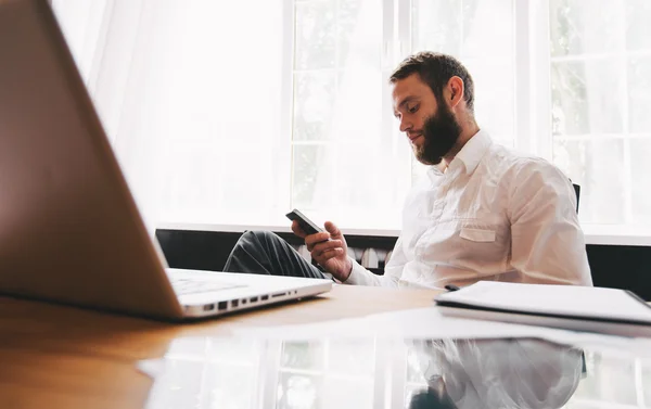 Trabalhador de escritório usando um telefone inteligente na mesa — Fotografia de Stock