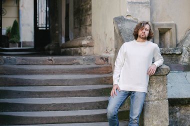 Beyaz sweatshirt ya da kapüşonlu bir adam Avrupa sokaklarında boş yeri olan logo tasarımları ya da tasarım baskıları yapıyor..