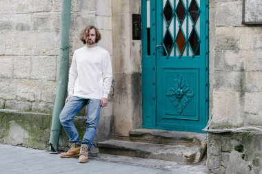 Beyaz sweatshirt ya da kapüşonlu bir adam şehrin sokaklarında boş yeri olan logo tasarımları ya da tasarım baskıları yapıyor..