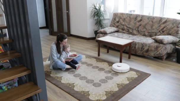 Robot Pembersih Vakum Membersihkan Ruang Tamu Sementara Ibu Dan Anak — Stok Video