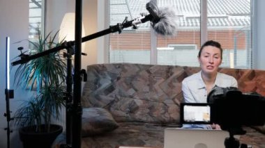 Kadın blogcu ya da video kaydedicisi evde konuşuyor