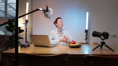 Kadın blogcu ya da video kaydedicisi evde konuşuyor