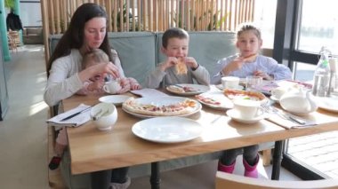 Aile restoranda pizza yiyor.