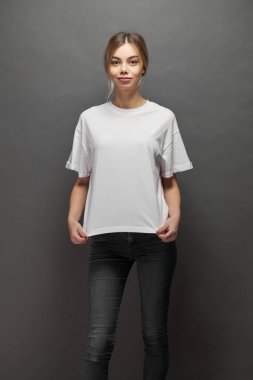 Logonuz için yeri olan beyaz, boş tişört giyen kadın, gri arkaplan üzerinde tasarım veya maket yapın