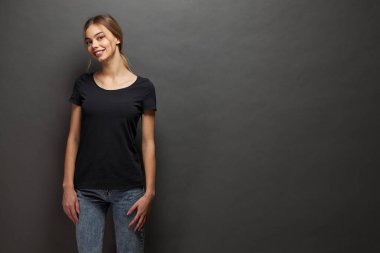 Logonuz için yeri olan siyah, boş tişört giyen bir kadın, gri arka plan üzerinde gelişigüzel kentsel tarzda tasarlayın ya da tasarlayın