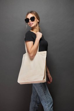 Model için taşıma çantası gri dokuya sahip bir kadın tarafından tutulur.