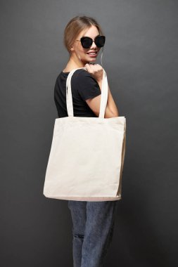 Model için taşıma çantası gri dokuya sahip bir kadın tarafından tutulur.