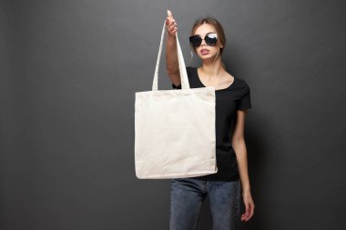 Model için taşıma çantası gri dokuya sahip bir kadın tarafından tutulur.