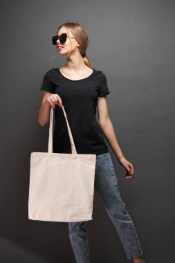 Model için taşıma çantası gri dokuya sahip bir kadın tarafından tutulur.