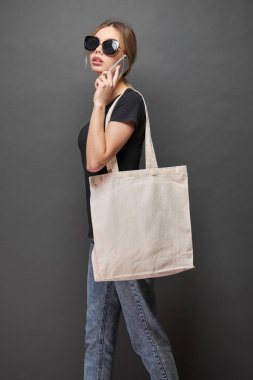 Model için taşıma çantası gri dokuya sahip bir kadın tarafından tutulur.