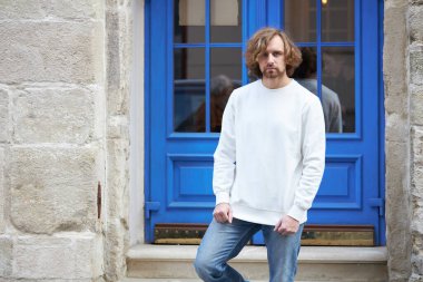 Beyaz kazak giyen bir adam. Tişört ya da kapüşonlu süveter, boş alanı olan logo tasarımları ya da tasarım baskısı.