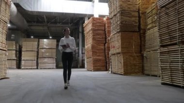 Marangoz fabrikasındaki iş kadını tablet bilgisayar kullanıyor. Marangozluk fabrikası. Parke tahtası üretimi için bir fabrika