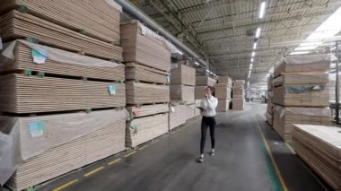 Marangoz fabrikasındaki iş kadını tablet bilgisayar kullanıyor. Marangozluk fabrikası. Parke tahtası üretimi için bir fabrika