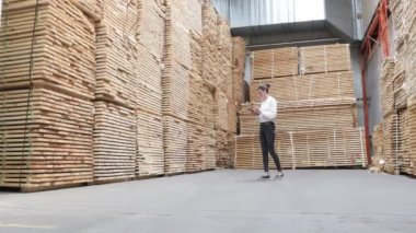 Marangoz fabrikasındaki iş kadını tablet bilgisayar kullanıyor. Marangozluk fabrikası. Parke tahtası üretimi için bir fabrika