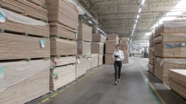 Marangoz fabrikasındaki iş kadını tablet bilgisayar kullanıyor. Marangozluk fabrikası. Parke tahtası üretimi için bir fabrika