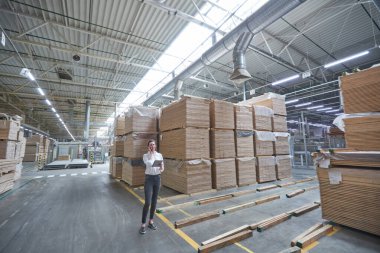 Endüstriyel Marangozluk fabrikasında çalışan bir iş kadını. Modern makineli ahşap tahta üretimi.